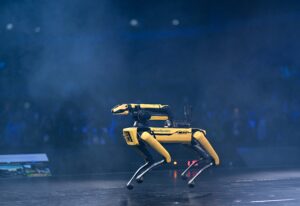 Robot pies Spot od Boston Dynamics z ramieniem chwytnym na scenie konferencji Web Summit 2025