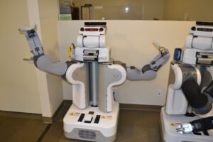 Dwuramienny robot badawczy PR2 z kamerami i czujnikiem głębi na głowie, obok drugi robot PR2