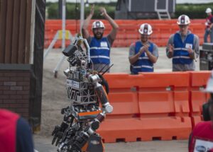 Robot ratowniczy na zawodach DARPA Robotics Challenge 2015, w tle kibicujący zespół
