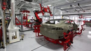 Robot przemysłowy przy nadwoziu samochodu na zrobotyzowanej linii montażowej
