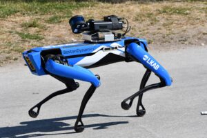 Robot Spot Boston Dynamics w niebiesko-białych barwach z logo LKAB, z czujnikiem pomiarowym na grzbiecie, na asfaltowej alejce