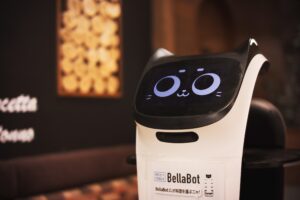 Robot kelner BellaBot z kocią twarzą na ekranie w restauracji w Japonii